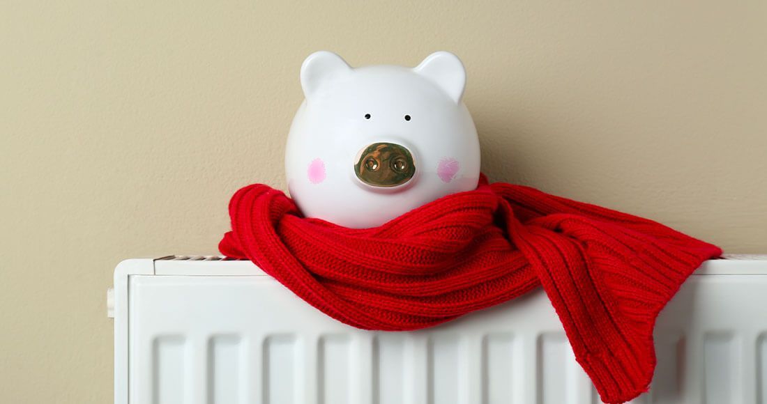 Tirelire cochon avec une écharpe sur un radiateur